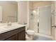 Bright bathroom featuring a single sink vanity and glass enclosed shower with a gray accent rug at 8929 Sleepy Panda Ave, Las Vegas, NV 89148