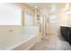 Bright bathroom featuring a bathtub, shower with glass enclosure and tiled floors at 8929 Sleepy Panda Ave, Las Vegas, NV 89148
