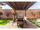Inviting outdoor patio featuring a dining area with pergola, lush lawn and attractive brickwork at 8941 Indigo Rose St, Las Vegas, NV 89166