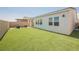 Well-kept back yard featuring green turf, modern furniture, and a neutral color palette at 8968 Skye Treeline St, Las Vegas, NV 89166