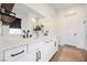 Bathroom with dual sinks, white cabinets, black hardware, and modern decorative touches at 8968 Skye Treeline St, Las Vegas, NV 89166