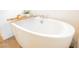 Bright bathroom featuring a soaking tub, modern faucet fixtures and wooden bath caddy at 8968 Skye Treeline St, Las Vegas, NV 89166