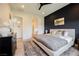 Nicely styled bedroom with dark blue accent wall, wood-look floors, and ensuite bath at 8968 Skye Treeline St, Las Vegas, NV 89166