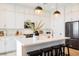 Close up view of the bright kitchen featuring white cabinetry, stainless appliances, and large island with seating at 8968 Skye Treeline St, Las Vegas, NV 89166