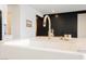 Close up of kitchen island and farmhouse sink with brass faucet and white countertops at 8968 Skye Treeline St, Las Vegas, NV 89166
