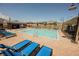 Gorgeous pool area with blue lounge chairs and tables, perfect for relaxation and socializing at 8968 Skye Treeline St, Las Vegas, NV 89166