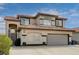 Two-story home featuring a red tile roof, arched entryway, two-car garage, and desert landscaping at 8983 Emerald Waters Ct, Las Vegas, NV 89147