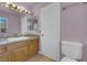 Bright bathroom featuring a granite countertop, framed mirrors, and commode at 9021 Feather River Ct, Las Vegas, NV 89117