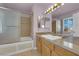 Bright bathroom featuring a vanity, granite countertop, framed mirrors, and glass-enclosed shower at 9021 Feather River Ct, Las Vegas, NV 89117