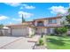 Beautiful two-story home with a well-manicured lawn, mature trees, and a tile roof at 9021 Feather River Ct, Las Vegas, NV 89117