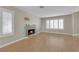 Spacious living room featuring a cozy fireplace, and large windows for natural light, complete with light hardwood floors at 9021 Feather River Ct, Las Vegas, NV 89117