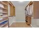 Spacious walk-in closet with custom shelves and racks and hardwood flooring at 9021 Feather River Ct, Las Vegas, NV 89117