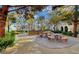 Outdoor gathering spot with stone tables and benches, surrounded by mature trees and landscaping at 10001 Peace Way # 1341, Las Vegas, NV 89147