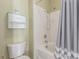 Bathroom with a shower and tub combination, a white tiled wall, and a white toilet and cabinet at 10191 Deerfield Beach Ave # 202, Las Vegas, NV 89129