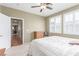 Bedroom featuring two shuttered windows, ceiling fan, carpet, and view into hall with hardwood floors at 10191 Deerfield Beach Ave # 202, Las Vegas, NV 89129