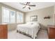 Comfortable bedroom with neutral walls, two windows with shutters, ceiling fan, and carpet flooring at 10191 Deerfield Beach Ave # 202, Las Vegas, NV 89129