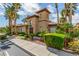 Community clubhouse featuring a tile roof, arched window, and lush landscaping at 10191 Deerfield Beach Ave # 202, Las Vegas, NV 89129