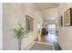 Inviting hallway with tile flooring and decorative art leads to the living room with hardwood floors at 10553 Pine Pointe Ave # 203, Las Vegas, NV 89144