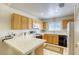 Functional kitchen with light wood cabinets, white countertops, and a black gas range at 10553 Pine Pointe Ave # 203, Las Vegas, NV 89144