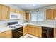 Well-lit kitchen featuring wood cabinets, white countertops, and a black oven range at 10553 Pine Pointe Ave # 203, Las Vegas, NV 89144