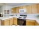 Bright kitchen with wood cabinets, white countertops, and black gas range oven at 10553 Pine Pointe Ave # 203, Las Vegas, NV 89144