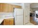 Bright kitchen featuring white refrigerator, white countertops, and wood cabinets at 10553 Pine Pointe Ave # 203, Las Vegas, NV 89144