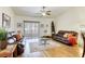 Comfortable living room features hardwood floors, stylish area rug, ceiling fan, and sliding door to patio at 10553 Pine Pointe Ave # 203, Las Vegas, NV 89144