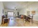 Open-concept living and dining area featuring hardwood floors, ceiling fan, and sliding door to patio at 10553 Pine Pointe Ave # 203, Las Vegas, NV 89144