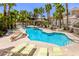 Resort-style pool area with ample lounge seating, lush palm trees, and inviting turquoise water at 10553 Pine Pointe Ave # 203, Las Vegas, NV 89144