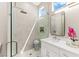 Modern bathroom featuring a glass shower, white marble tile, and a bright window at 10557 Shoalhaven Dr, Las Vegas, NV 89134