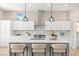 Modern kitchen with white cabinets, stainless steel appliances, and island with breakfast bar seating at 10557 Shoalhaven Dr, Las Vegas, NV 89134