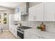 Modern kitchen boasts white cabinets, granite countertops, stainless steel appliances, and tile backsplash at 10557 Shoalhaven Dr, Las Vegas, NV 89134