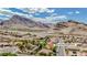 Scenic aerial view of a charming neighborhood nestled against a backdrop of majestic mountains and a bright, sunny sky at 10709 Hunters Woods Pl, Las Vegas, NV 89134