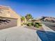 Single-story home featuring desert landscaping, a two-car garage, and a well-maintained lawn at 10709 Hunters Woods Pl, Las Vegas, NV 89134