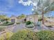 Well maintained front yard featuring gravel landscaping, mature trees, bushes, and privacy fence at 10709 Hunters Woods Pl, Las Vegas, NV 89134