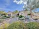 Charming front yard featuring desert landscaping, mature trees, and a well-manicured lawn at 10709 Hunters Woods Pl, Las Vegas, NV 89134