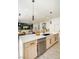 Kitchen island features wooden cabinetry, modern black hardware, and stainless steel dishwasher in a bright area at 10709 Hunters Woods Pl, Las Vegas, NV 89134