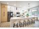 Bright kitchen with stainless appliances, light wood floors, white cabinets, and a large center island with seating at 10709 Hunters Woods Pl, Las Vegas, NV 89134
