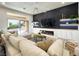 Modern living room with a large sectional couch, fireplace, entertainment center, and sliding glass door to the backyard at 10709 Hunters Woods Pl, Las Vegas, NV 89134