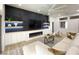 Living room with modern decor, featuring a fireplace, custom shelving with lighting, and a comfortable sectional sofa at 10709 Hunters Woods Pl, Las Vegas, NV 89134