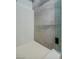 Modern walk-in shower with white honeycomb tile flooring and a sleek glass enclosure at 10709 Hunters Woods Pl, Las Vegas, NV 89134