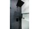 Modern shower features a black rainfall shower head, textured gray tile, and a built-in shelf at 10709 Hunters Woods Pl, Las Vegas, NV 89134