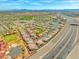 Expansive aerial view of a well-planned community with a highway nearby and mountains in the distance at 10809 Garden Mist Dr # 1004, Las Vegas, NV 89135