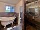 Well-lit bathroom with a clawfoot tub and a glass enclosed shower at 1105 Enderly Ln, Las Vegas, NV 89144