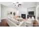 Bright, staged living room featuring a fireplace, ceiling fan and wood floors at 11079 Zampino St, Las Vegas, NV 89141