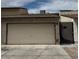 View of the garage door of a one-story home with a black metal gate to the right at 1203 Mews Ln, Las Vegas, NV 89101