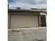 View of the garage door of a one-story home with a black metal gate to the right at 1203 Mews Ln, Las Vegas, NV 89101
