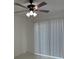 Bright living room features tile flooring, a ceiling fan, and sliding door access to the backyard at 1203 Mews Ln, Las Vegas, NV 89101