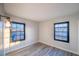 Bedroom featuring gray wood-look floors, two windows, and a modern wall sconce at 170 Copper St, Henderson, NV 89015