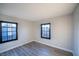 Bedroom featuring gray wood-look floors, two windows, and neutral walls for a calm atmosphere at 170 Copper St, Henderson, NV 89015